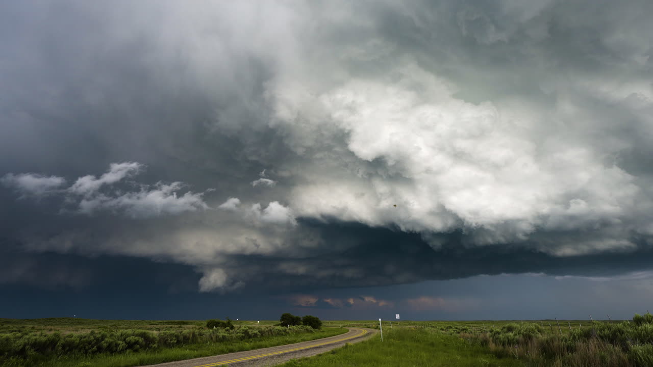 Time Lapse Winding Road With Stunning Stormy Textured Clouds Moving Above Colourful Fields
