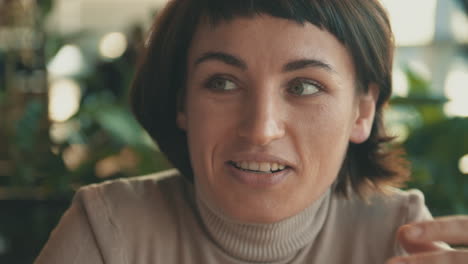 Portrait-Of-Young-Woman-Talking-To-Her-Friend-In-A-Coffee-Shop-1