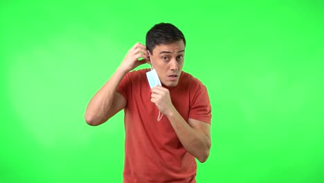 man's varied reactions and struggles with a face mask on green screen