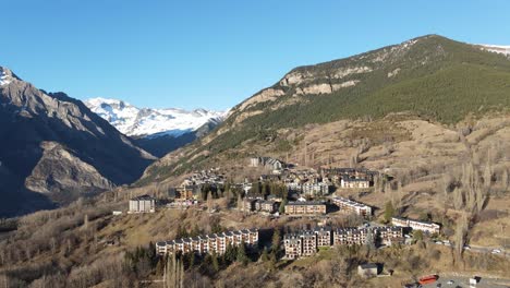 scenic aerial view of small mountain village with snow peak in the background, pyrenees, spain