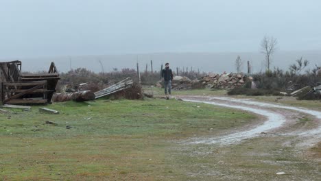 solitary man walk towards camera on a devastated place