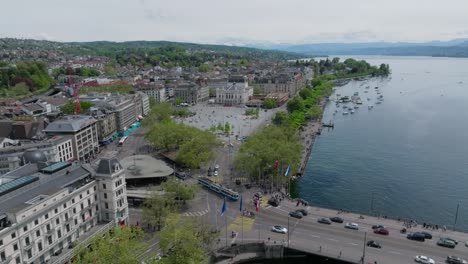 Langsam-Vorwärts-Fliegende-Umlaufende-Drohne,-Die-Das-Zürcher-Opernhaus,-Die-Stadtbewohner,-Den-Verkehr,-Die-Skyline-Und-Das-Seeufer-Zeigt