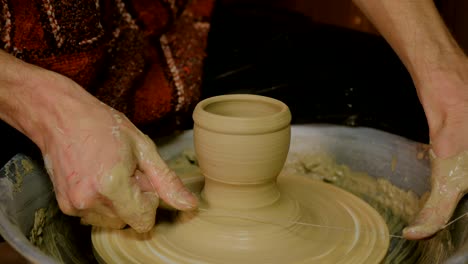 professional male potter working in workshop, studio