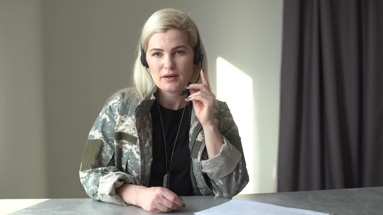 Happy soldier woman smiling while making conference call on laptop indoors.