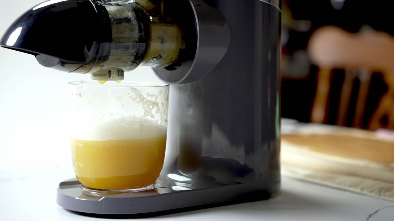 Healthy drinks, freshly squeezed orange fruit, masticating juicer machine