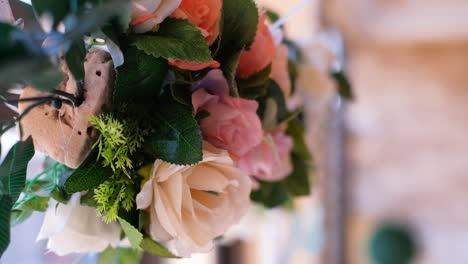 close up of flowers hanging from an arch during wedding ceremony