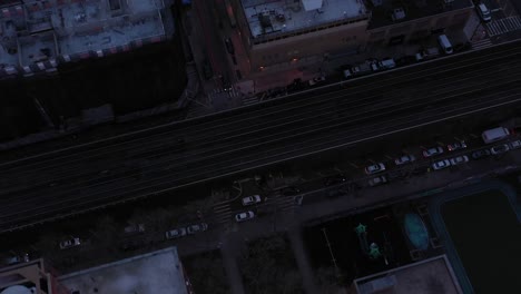 Corta-Toma-De-Drones-Hacia-Abajo-De-Tejados-Y-Vías-De-Tren-En-Harlem,-Ciudad-De-Nueva-York,-Justo-Después-Del-Amanecer,-En-4k