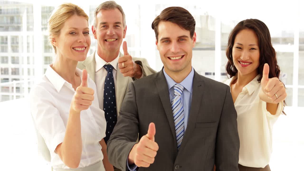 equipo de negocios dando pulgares hacia arriba a la cámara
