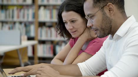 concentrated young people reading information from laptop