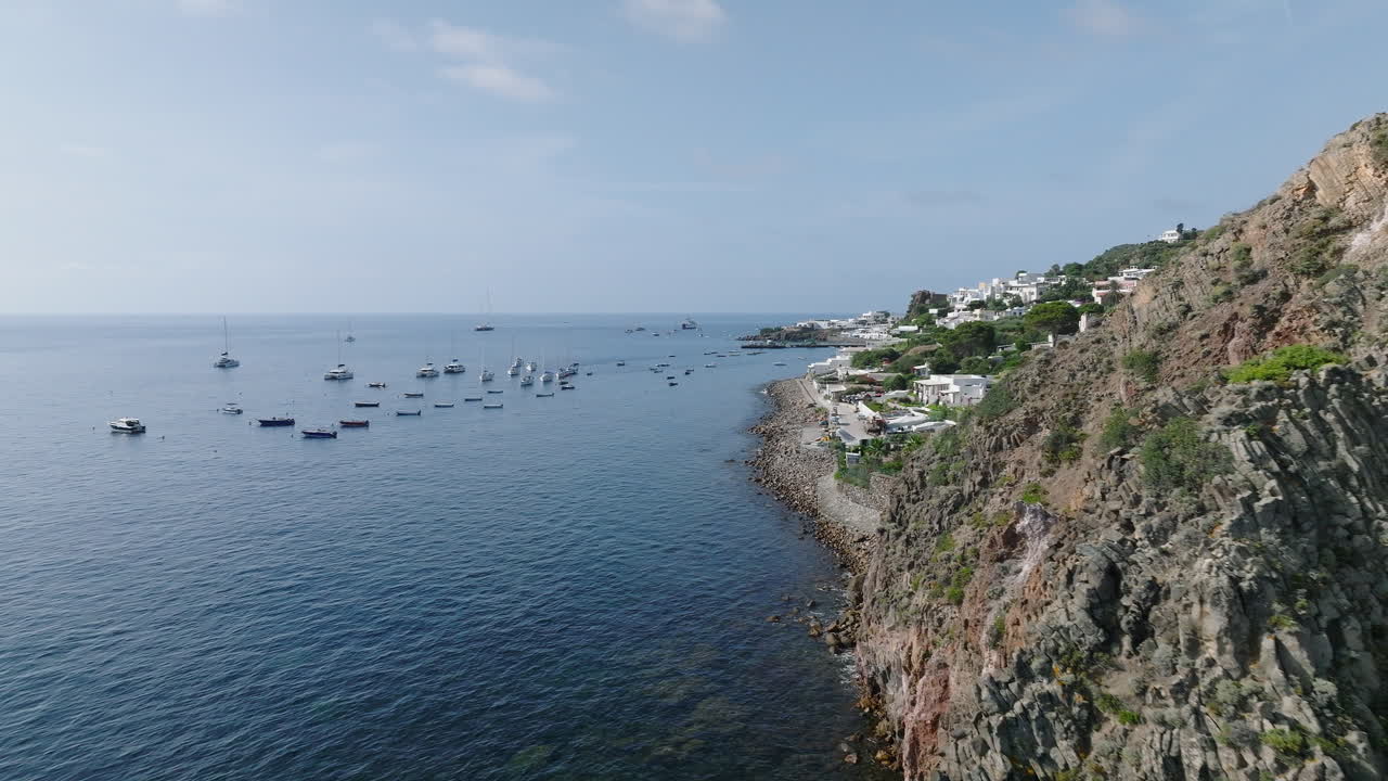 4K Aerial of Panarea, Aeolian Islands. Slow push in past cliff to reveal town in the background