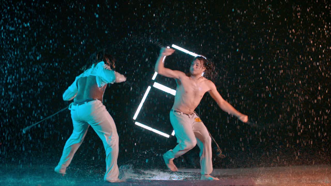 Men train Capoeira indoor wet studio, caucasian and black men practicing fight