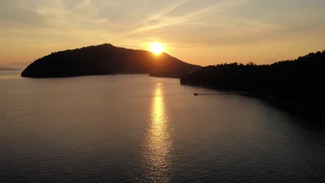 a stunning sunset over kri island in raja ampat, idonesia, captured with an aerial boom shot moving down