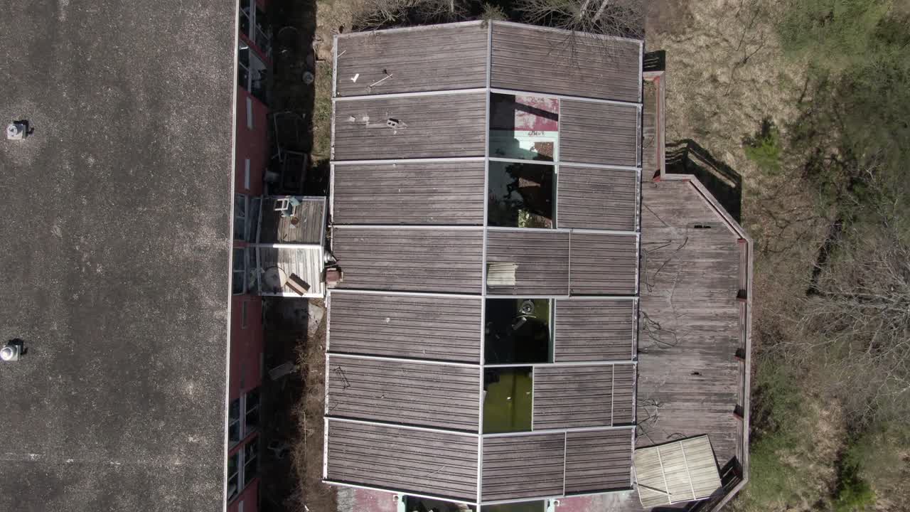 imágenes aéreas de drones de arriba hacia abajo avanzando sobre una piscina cubierta abandonada y un hotel