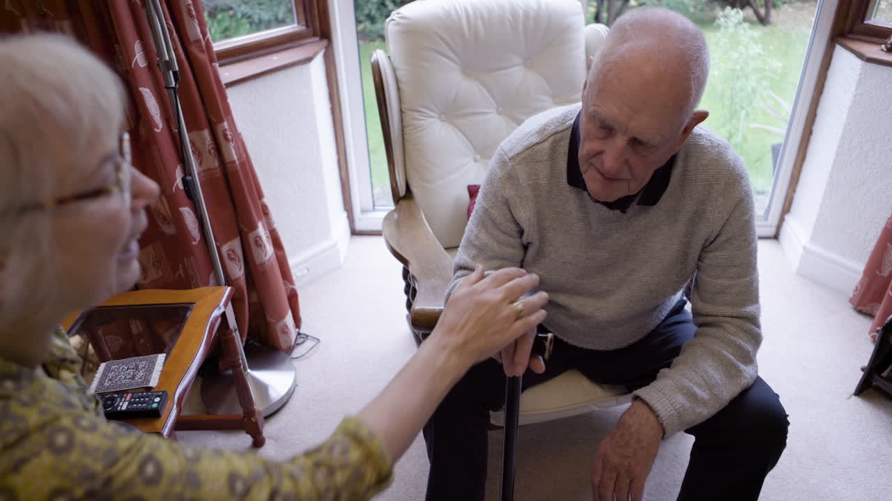 An elderly couple talking together indoors