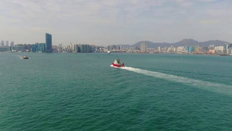 Small-Offshore-supply-ship-roaring-across-Hong-Kong-bay,-Aerial-view