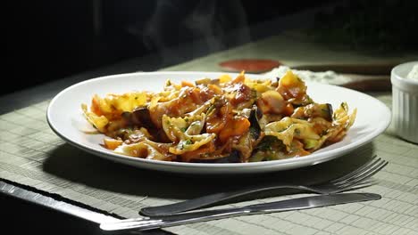 A-famous-italian-dish-as-known-as-farfalle-made-with-a-spicy-sauce-on-a-cooking-table-with-wooden-tablecloth