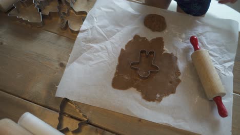 a child is baking gingerbread cookies at christmas with family