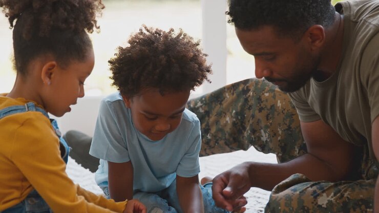 Padre militare in uniforme a casa in licenza con i figli che fanno un puzzle insieme