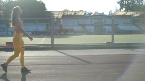 mujer caminando por una pista de atletismo