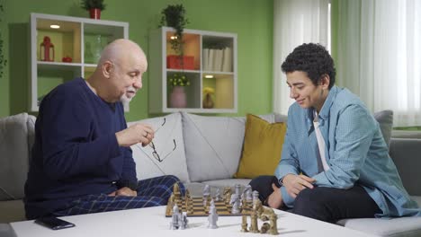 el lindo abuelo juega al ajedrez con su nieto.