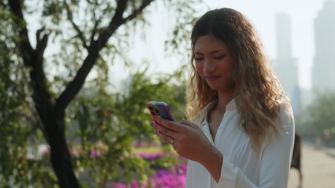joven usando un teléfono inteligente en un parque