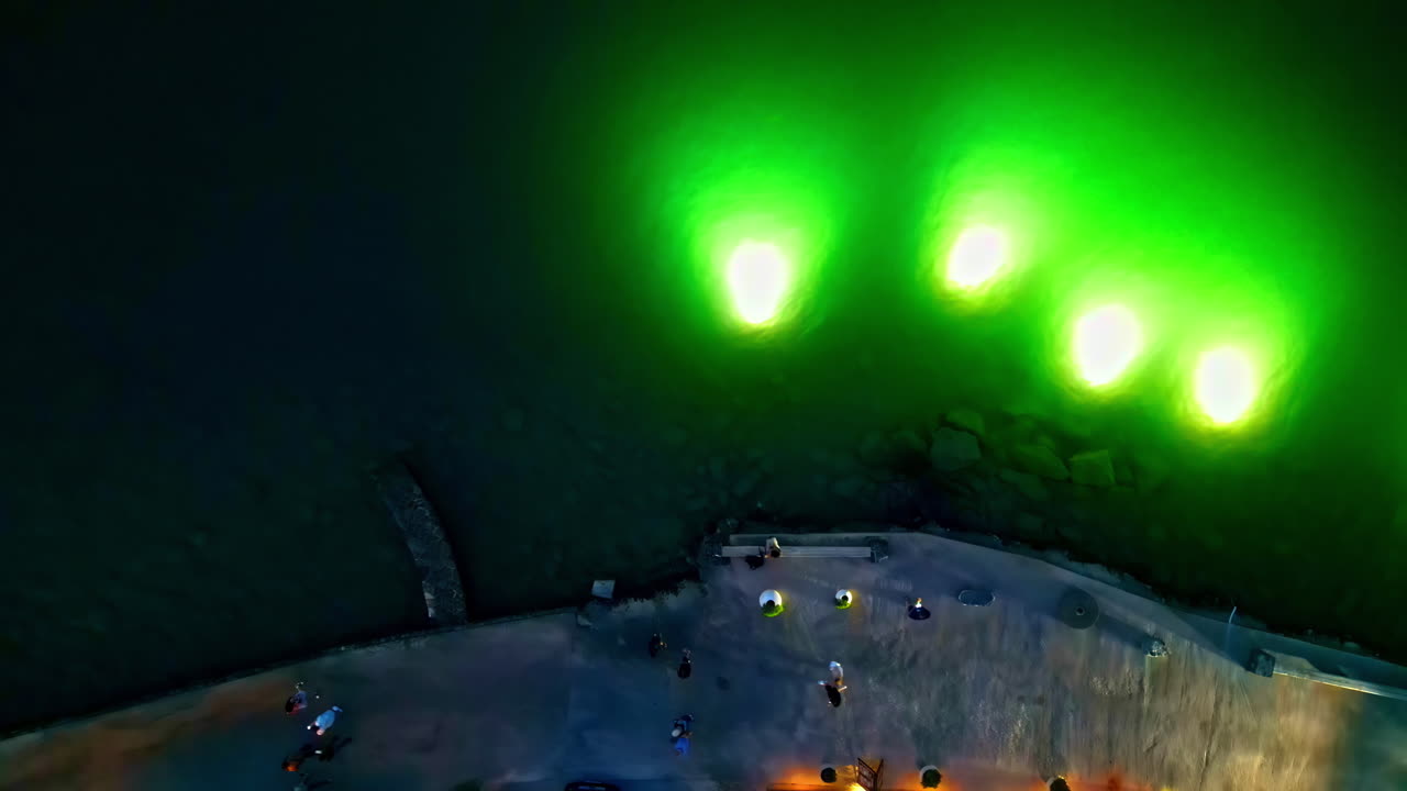 Greek city promenade walk at seaside with green display lights Agios Nikolaos, aerial top down view