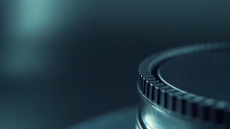 a macro close up professional shot of a black plastic wheel, on a 360 rotating stand, cinematic studio lighting, 120 fps, slow motion, full hd