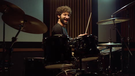 Happy-drummer-having-fun-in-recording-studio.-Happy-man-playing-drum-kit-indoor.