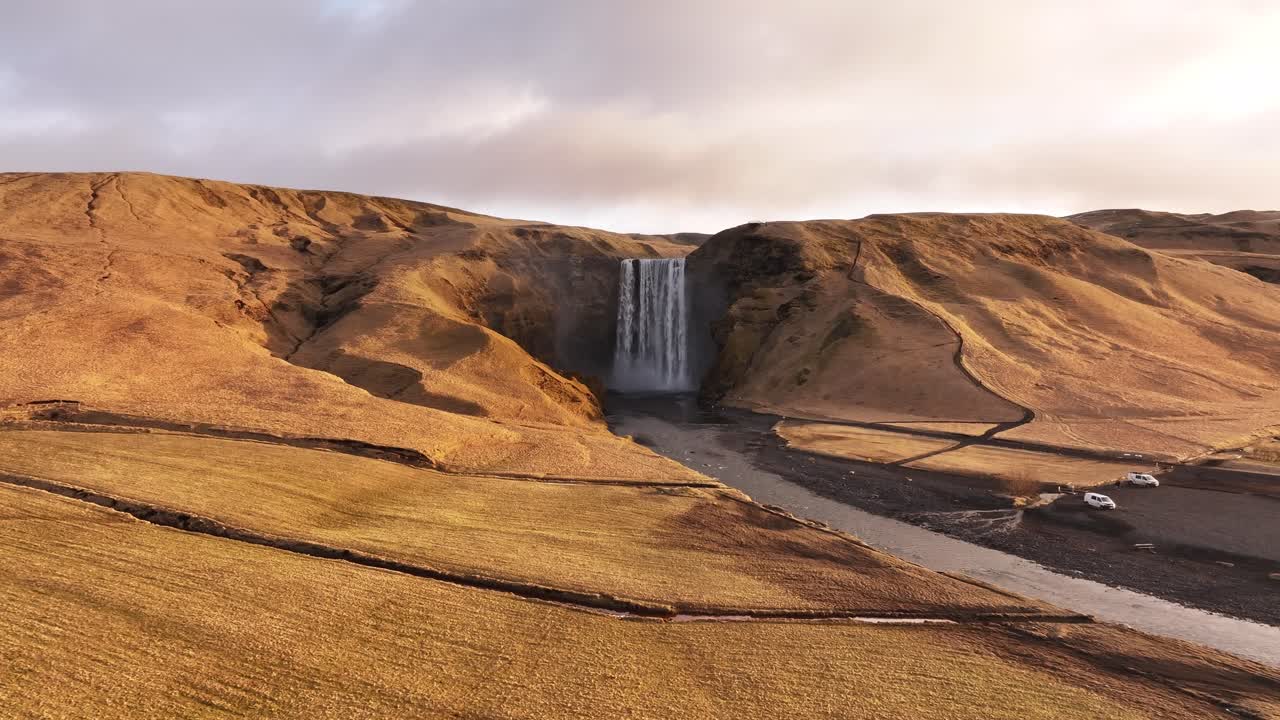 aerial - Skógafoss waterfall glowing at sunrise in south Iceland