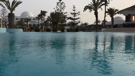 Low-angle-water-surface-perspective-of-swimming-pool-of-luxury-holiday-resort-in-Tunisia-on-windy-day