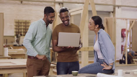 a team of designers using a laptop together