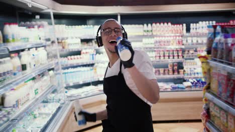 Glücklicher-Arbeiter-Im-Supermarkt,-Der-Zu-Den-Milchflaschen-Tanzt-Und-Singt