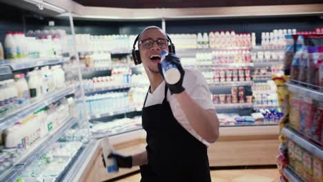 happy worker on supermarket dancing and singing to the milk bottles