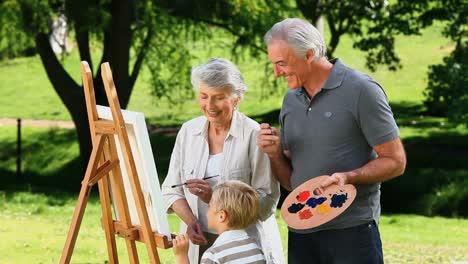y los abuelos del niño pintando un lienzo blanco