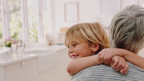 niño, sonrisa y abrazo a la abuela en la cocina