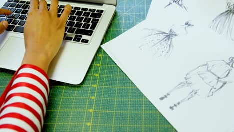 Fashion-designer-using-laptop-in-fashion-studio-4k