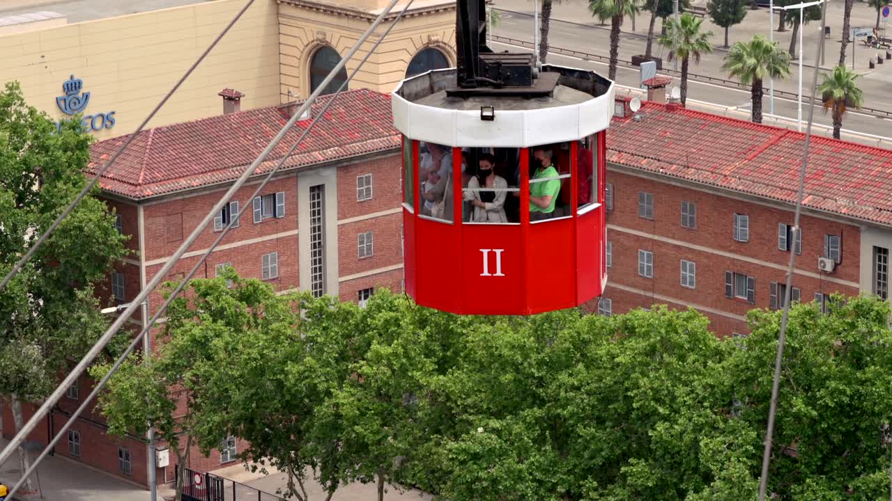 Barcelona, Spain - June 25, 2021: People riding the Cable Car at the Port Station