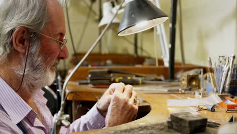 goldsmith working at table in workshop 4k