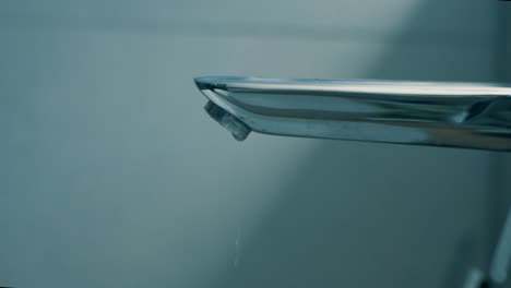 Water-Drops-From-Stainless-Faucet.---close-up