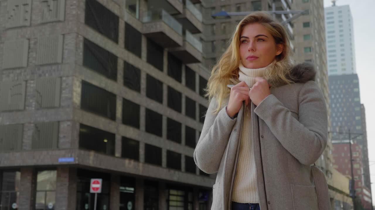 Giovane donna bionda e sicura di sé che guarda in lontananza.