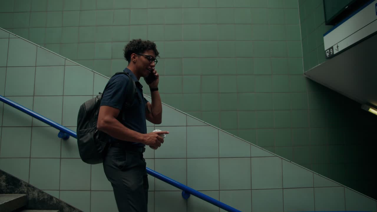 Man with backpack on cellphone at stairs
