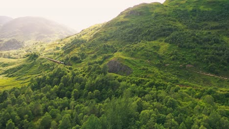 aerial view of the jacobite steam train approaching the glenfinnan viaduct in the scottish highlands, scotland, united kingdom