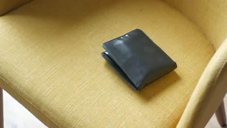 black leather wallet on a yellow chair