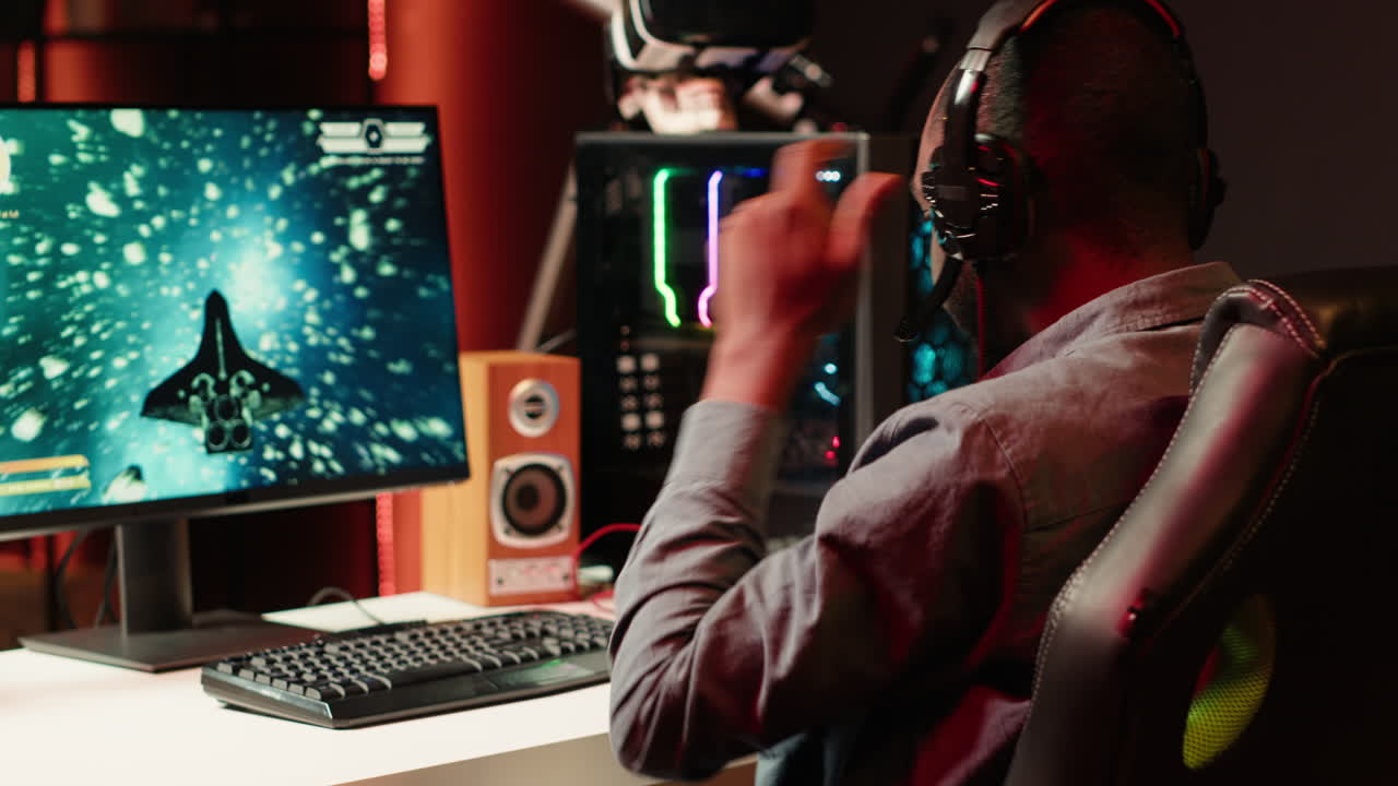 Man playing SF shooter videogame, talking into headset with friends