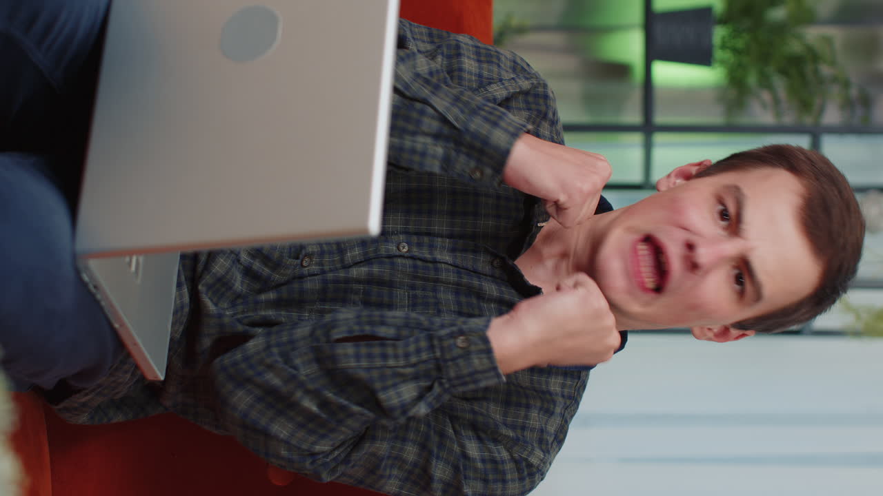 hombre celebra el éxito mientras trabaja en la computadora portátil