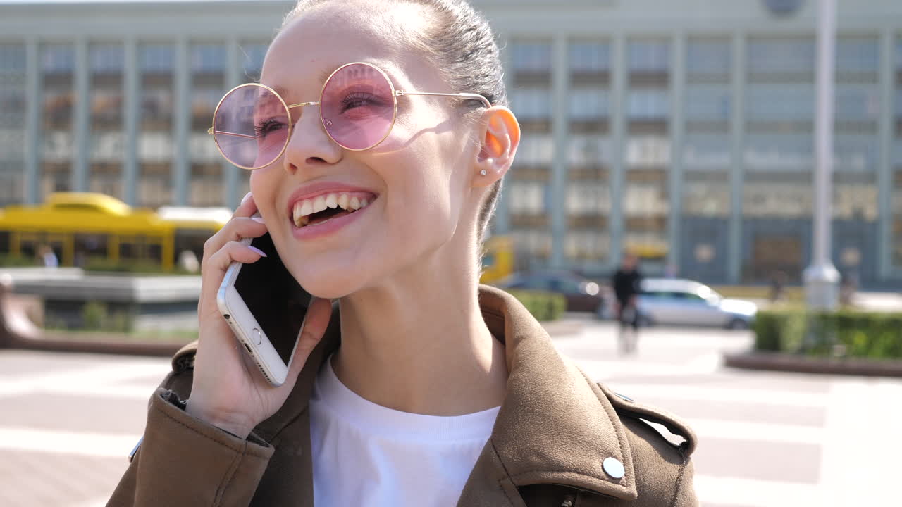 mujer sonriente hablando por teléfono en la ciudad
