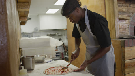 hombre de raza mixta haciendo una pizza
