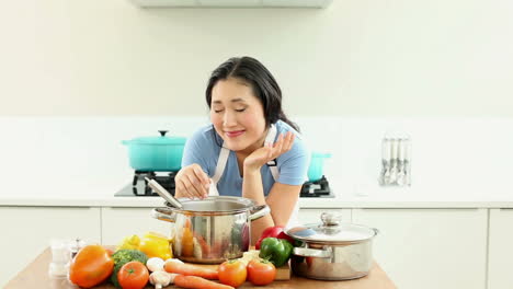 Happy-woman-seasoning-pot-and-smiling-at-camera