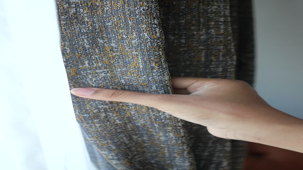 회색과 노란색 커튼을 열는 손