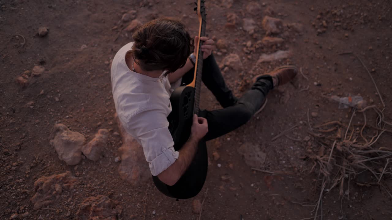 Man playing guitar in the desert